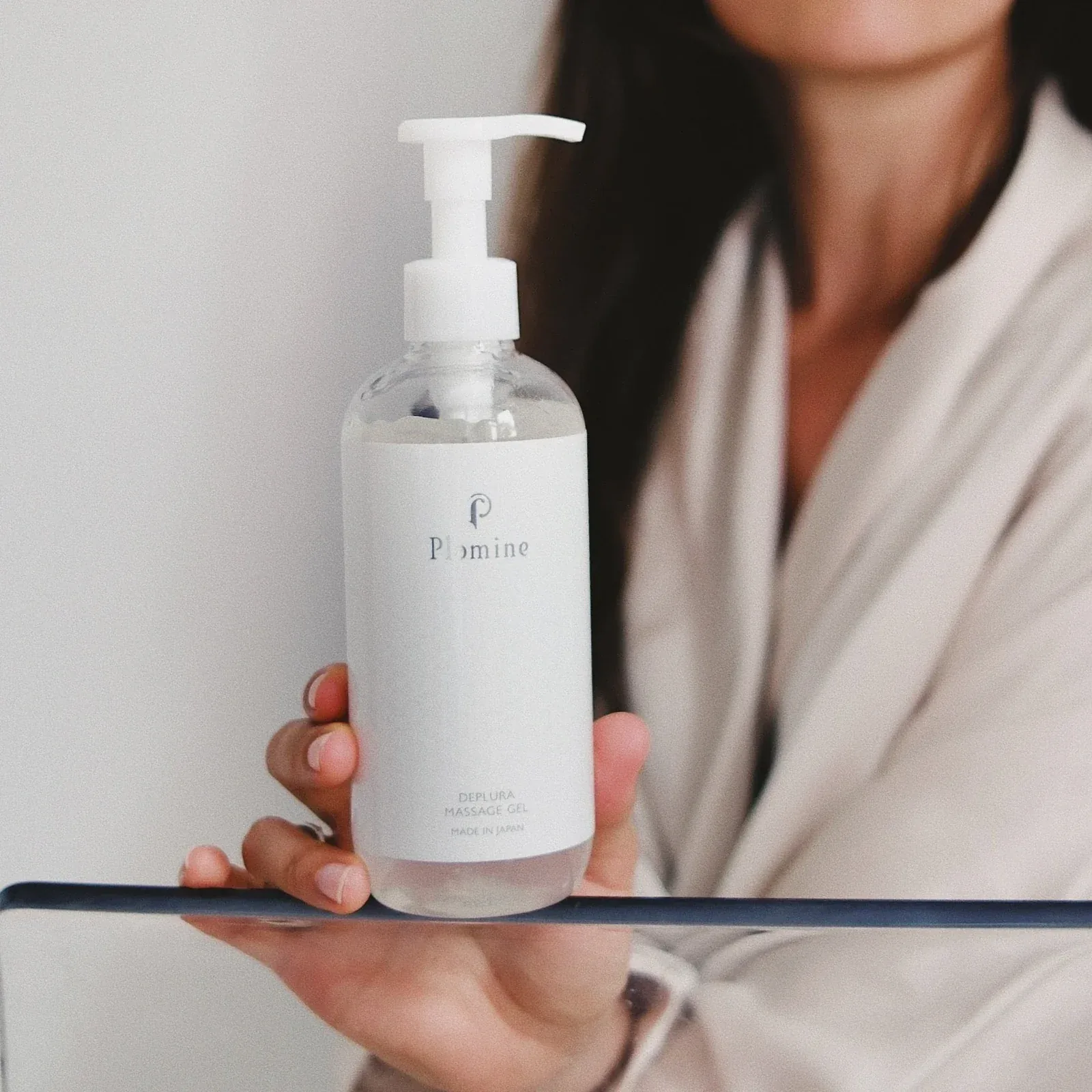 Woman holding a bottle of Plamine Deplura Massage Gel